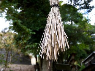Faded straw rope tassel hanging from the torii