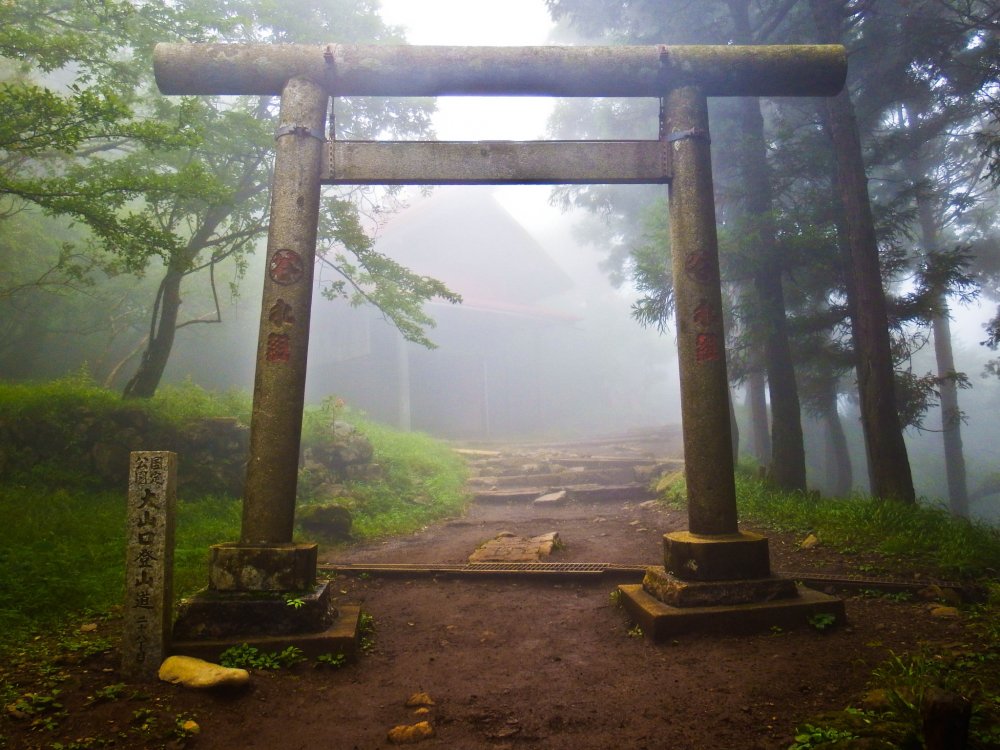 The main `torii` (gate) on the approach to Upper Afuri Jinja with the main shrine several meters away in the foggy distance