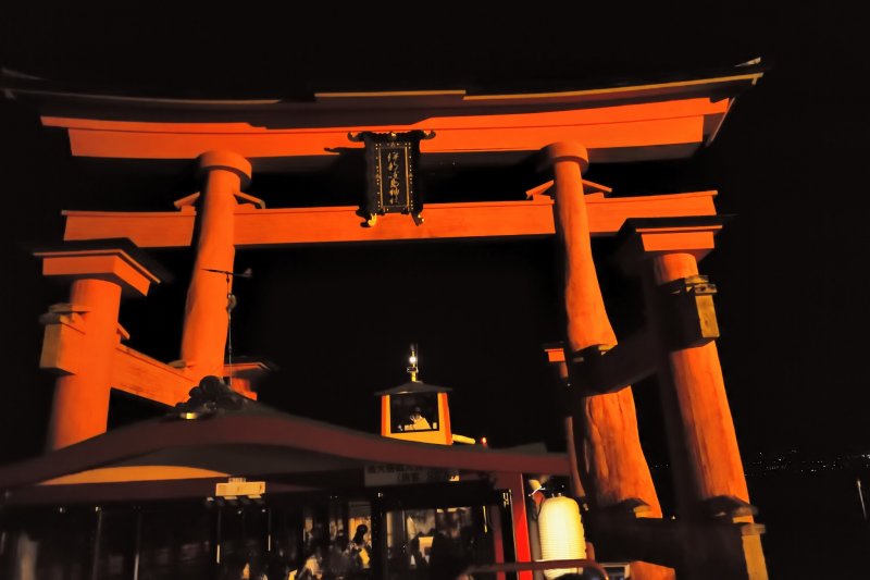 <p>My boat passing through the torii gate which towers over it as we get closer</p>