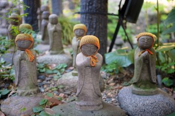 <p>Jizo figures with orange hats</p>