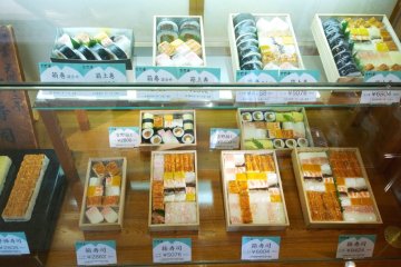 <p>รูปอาหารจำลองด้านหน้าร้านชั้นล่างที่โชว์ให้เห็นความหลากหลายของความอร่อยในสไตล์ซูชิกล่องของ&nbsp;Yoshino Sushi (吉野寿司)</p>