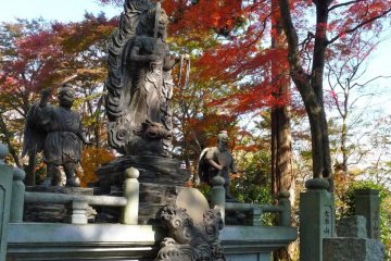 These statues of gods are striking against the fiery colors of the autumn leaves.