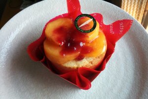 Persimmon panier - a slice of cream-filled roll cake, topped with creamy custard, persimmon and raspberry sauce