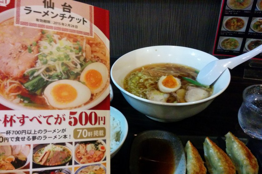 The cover of the book next to some ramen