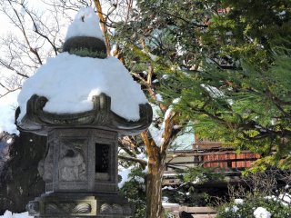 雪の帽子を被った庭園の石灯籠