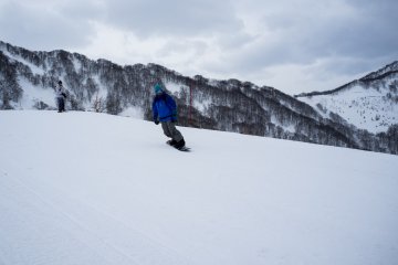 <p>Snowboarder testing out his moves on the beginner&#39;s slope</p>