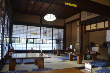 Гостиная главного дома, оформленная в традиционном японском стиле.  Здесь можно пообедать, любуясь двором усадьбы сквозь застекленные юкими сёдзи -  раздвижные перегородки, отделяющие внутренние помещения от пространства двора. 