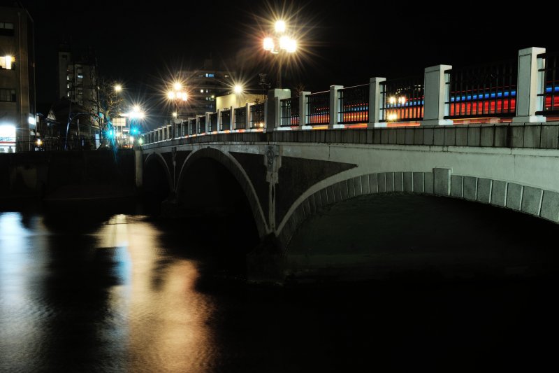 <p>Свет фонарей льется с речного моста Асано</p>
