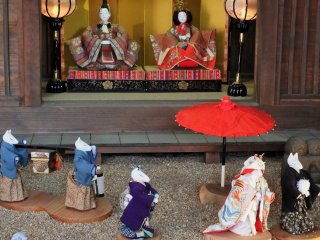 These traditional hina dolls are being visited by a collection of kimono-clad foxes in a wedding procession!