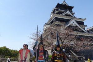 ครอบครัวน่ารักกำลังถ่ายภาพกับปราสาทคุมะโมะโตะ