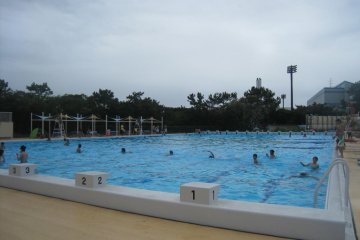 The 50 meter pool for swimmers, with only a few person who were practising their skills.