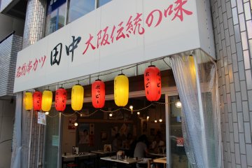 <p>쿠시카츠 타나카의 외관 - &#39;오사카 전통의 맛 꼬치 튀김&#39;이라고 쓰여져 있다.</p>