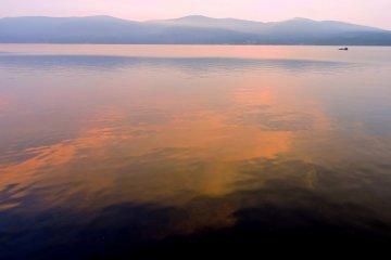 <p>ท้องฟ้าอันกว้างใหญ่ที่กำลังทองแสงสีทองประกายส้มอันอบอุ่นกำลังสะท้อนลงบนผิวน้ำของทะเลสาป เป็นภาพที่งดงามและนุ่มนวลมาก</p>
