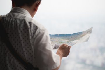 <p>Man reading a map overlooking Tokyo</p>