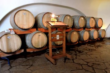 <p>Stacked barrels bear the entrance of Akafuji Wine Cellar</p>