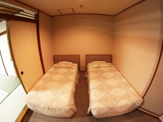 Phía khác của căn phòng là 2 chiếc giường theo phong cách phương tây, cũng như một chiếc bàn nhỏ, 2 chiếc ghế và một tủ lạnh nhỏ