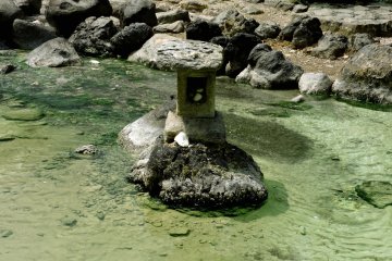 A rough stone lantern standing in the stream