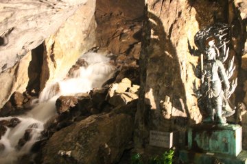 <p>The underground waterfall and the statue of Fudomyo-sama in the largest chamber of the cave</p>