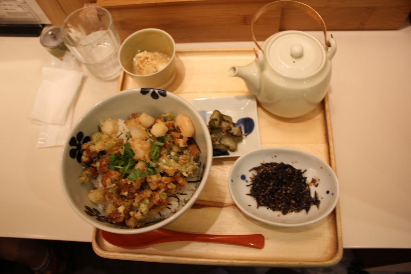 Большая порция риса в креветками, чайник с чаем, цукемоно в виде огурцов, тофу и водоросли
 