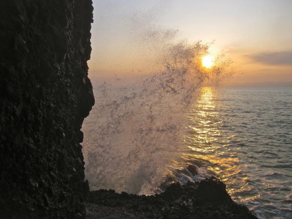A breaking waves makes a grab for the setting sun