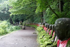 74 Jizo statues lined up along the riverside path