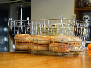 A basket of freshly-baked plain bagels
