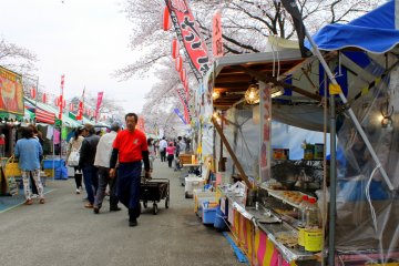 The road has a long line of colorful stalls selling all sorts of snacks, toys and drinks