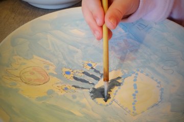 A young visitor tries her hand at pottery painting