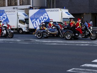 Motorcyclist group wearing Santa costumes passing by Kyoto City Hall during the Christmas season