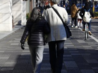 Pasangan senior yang sedang berjalan kaki dengan nuansa romantis menuju Balai Kota Kyoto pada musim dingin
