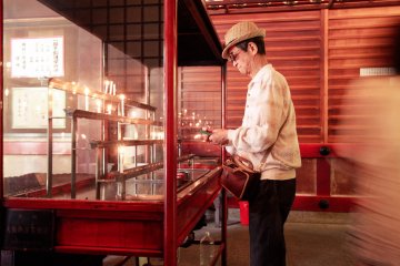 A man lighting a candle inside Ichigandou Hall