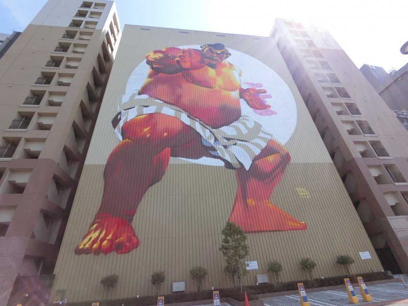 Гигантский 12-этажный сумоист работы немецкого художника Кейса Маслайма. На его создание для  POW! WOW! Japan 2015 ушло 47 часов
