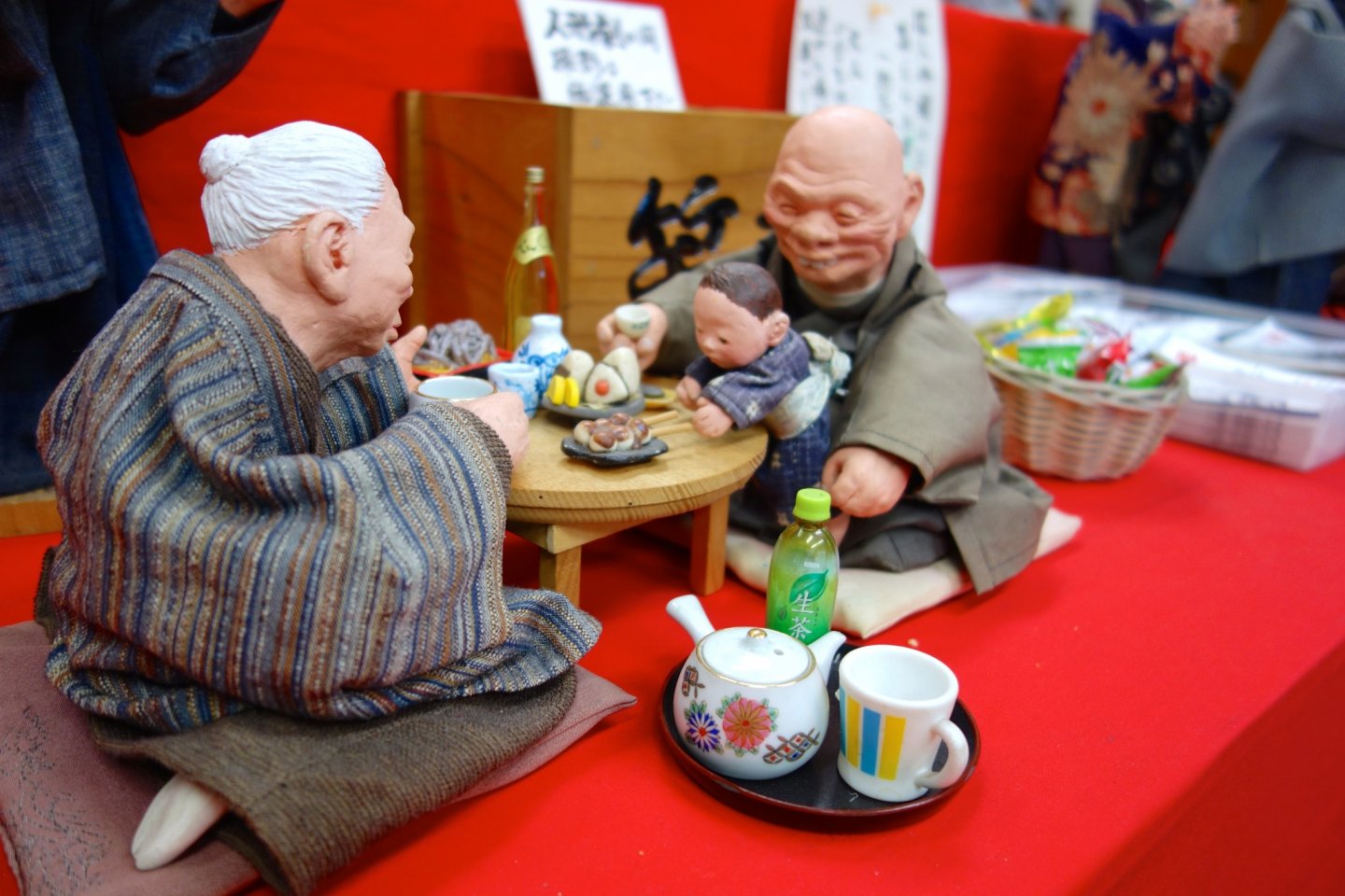 The puppets depict an intimate home scene between an elderly couple and their grandchild, presumably