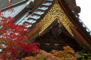 Массивная крыша храма в окружении красивой осенней листвы