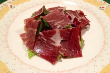 Green salad, covered in Iberico ham
