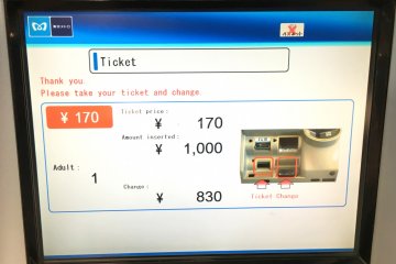 Once the transaction is complete, your ticket and your change will come out of the highlighted slots on the machine, below the screen.