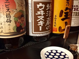 Botol besar yang berisi sake, whiskey, dan alkohol yang terbuat dari buah prem