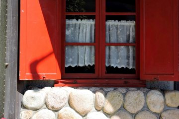 Red shutters and lace curtains