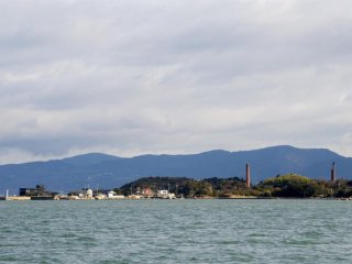 Pulling into port with the chimneys of the ruined copper refinery that now houses the Inujima Art Project