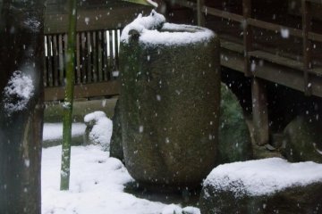 전통적인 대나무 물 공급 장치가 눈 속에 얼어 있다.