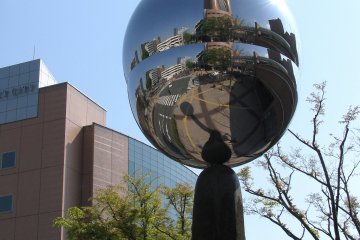 Зеркальный объект, отражающий площадь возле башни
