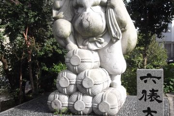 A jolly Buddhist deity with some sake barrels