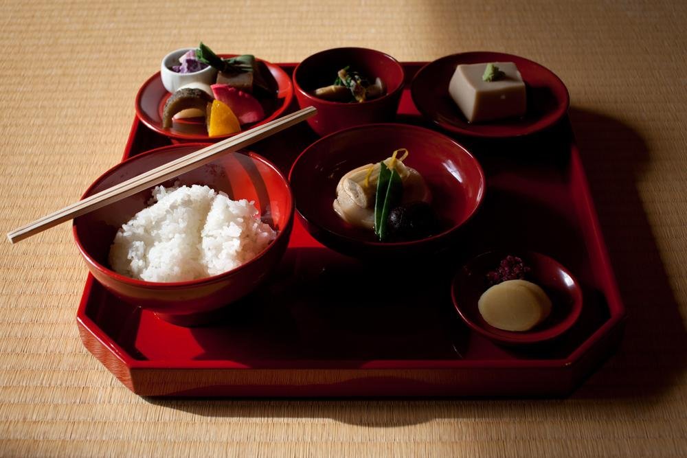 L&#39;ensemble du repas se compose de riz, soupe, l&eacute;gumes, haricots et des pr&eacute;parations de tofu vari&eacute;es, le tout servi sur un plateau de laque rouge