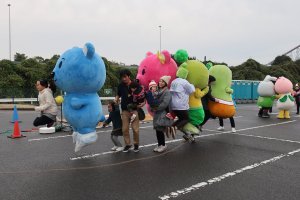 Mascots skipping together with visitors