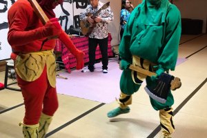 Oni demonstrate their weapons at live music event