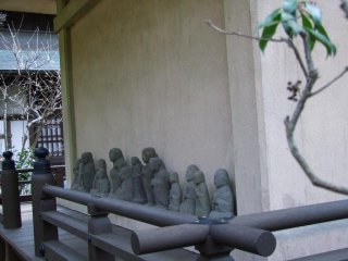 Flat statues lining one side of the temple