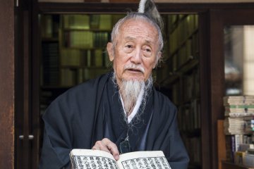 오카다는 작은 서점에서 백여년 된 책을 여행자에게 보여주고 있다