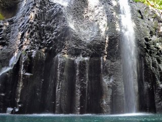 Água em cascata por cima das rochas em direcção ao desfiladeiro