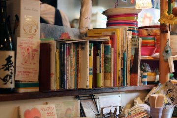 Books fill the shelves surrounding the chef's area. Feel free to peruse while waiting for your meal.