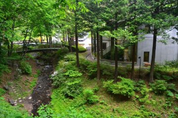 <p>작은 개울과 숲에 둘러싸여 있던 구지 호박 박물관 본관의 뒷 모습</p>